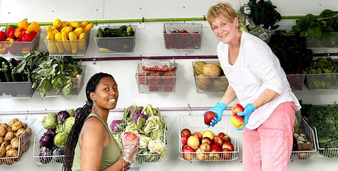 A scholar and nonprofit partner sorting fruits and vegetables.