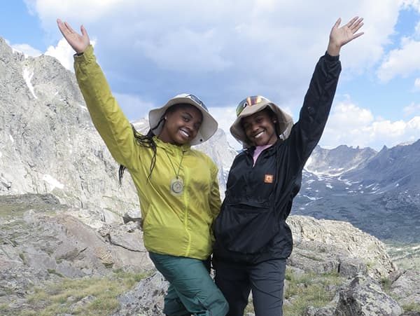 Two scholars posing on a mountain top during the NOLS expedition.