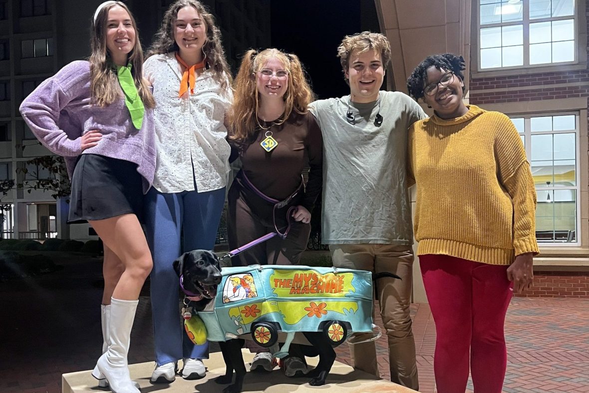 Scholars displaying their group costume of Scooby Doo at an event.