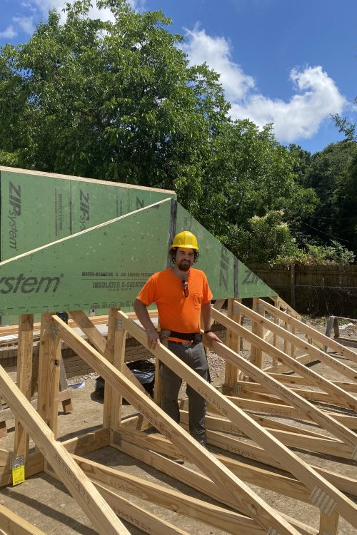 A scholar helping to create a roof structure for Habitat for Humanity.