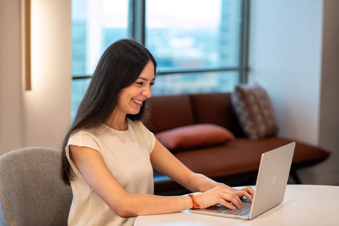 A scholar typing on a laptop computer.