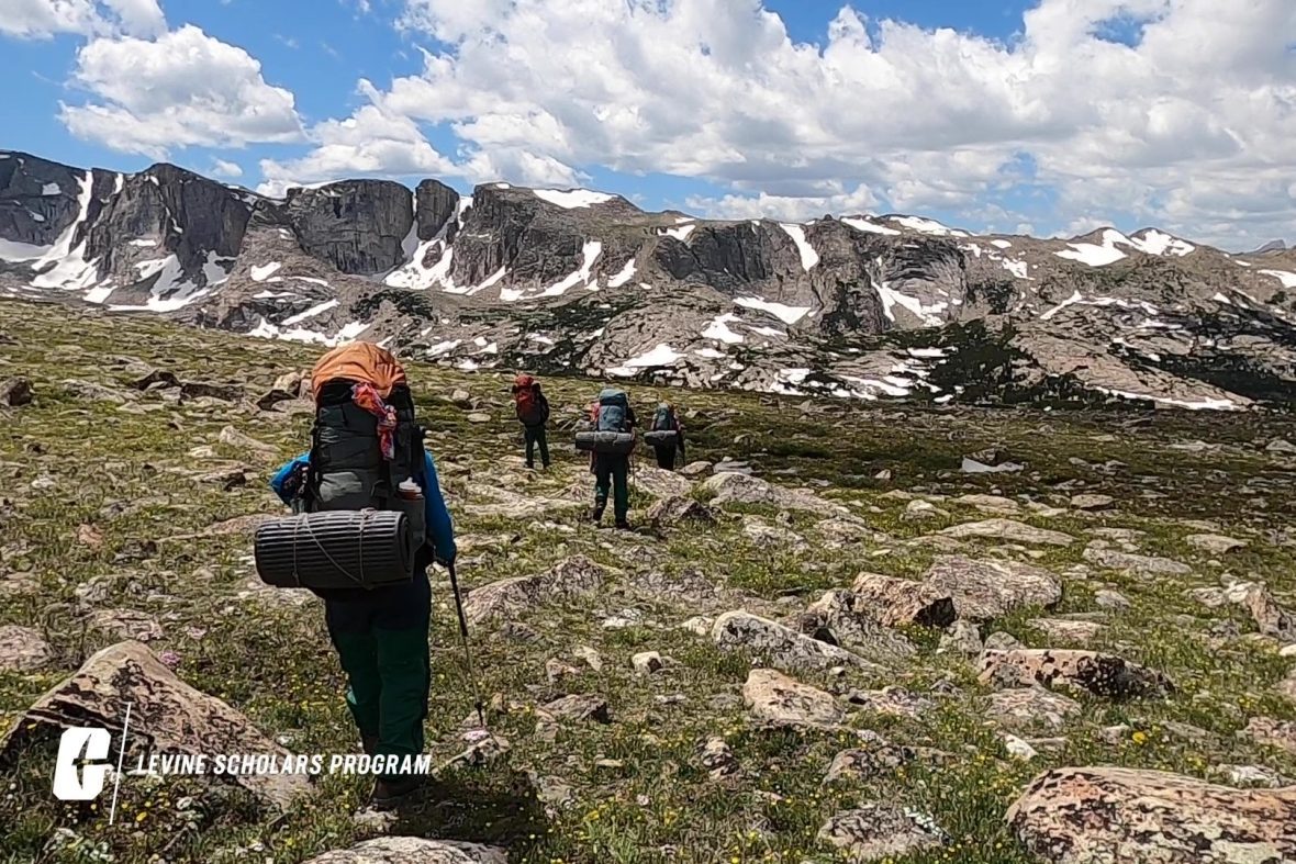 A group of scholars hiking through Wyoming mountains during NOLS expedition.