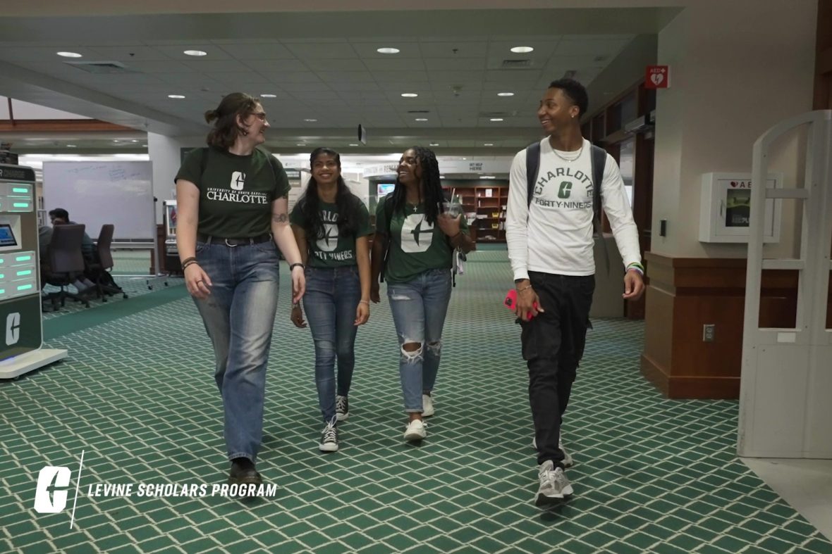 A group of scholars walk through Atkins Library.
