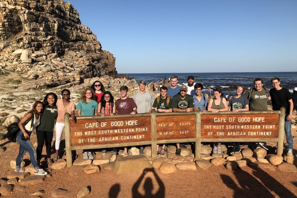 Group of students standing at the Cape of Good Hope sign in South Africa.