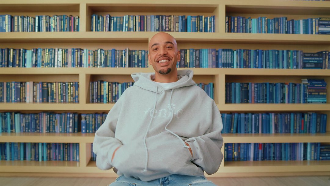 Brandon Nixon ’16 in front of a bookcase with blue books